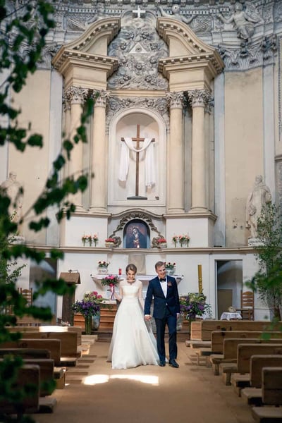 Jaunieji eina bažnyčios praėjimu po vestuvių ceremonijos